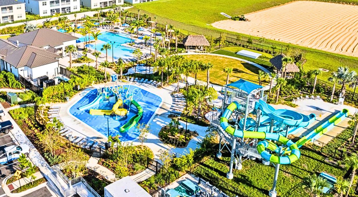 A resort with multiple swimming pools, a water park, and a large grassy area.