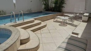 Relax by the pool surrounded by lush greenery and enjoy a refreshing swim.
