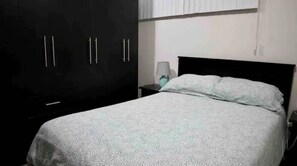 Comfortable accommodations feature a large bed, wardrobe, and nightstand with a lamp.