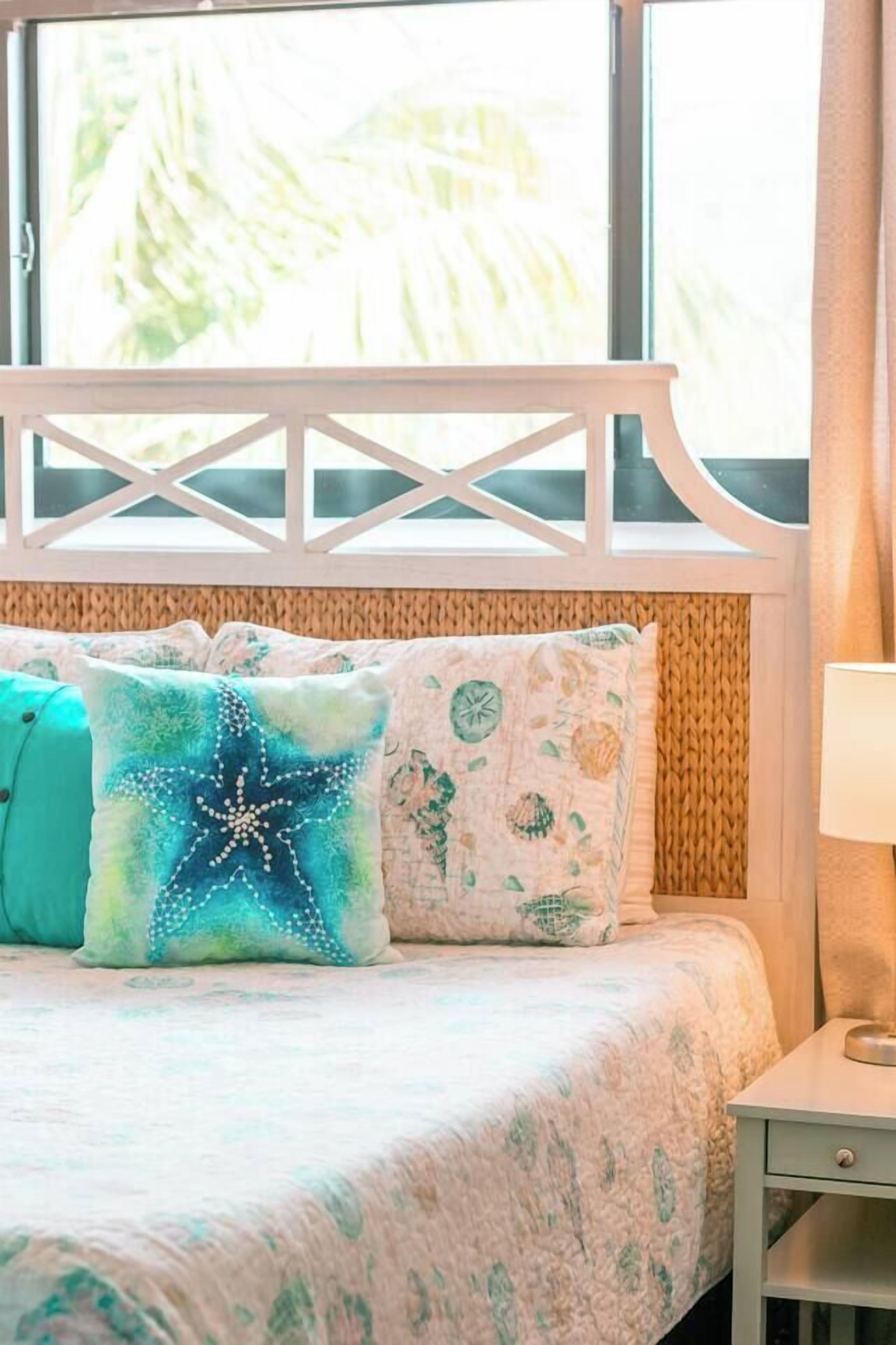 Une chambre à coucher avec un lit, une fenêtre donnant sur la verdure et une tête de lit en bois.