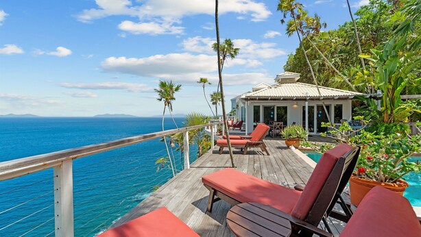 A wooden deck with red lounge chairs and a pool, overlooking a clear blue sea with distant land. - Private Pool, Sun Deck, Cliffside, Ocean Views, AC (St. Thomas)