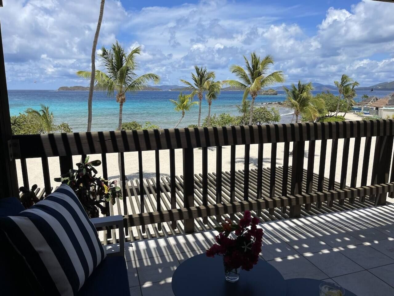 Ein Balkon mit Blick auf den Ozean und Palmen.