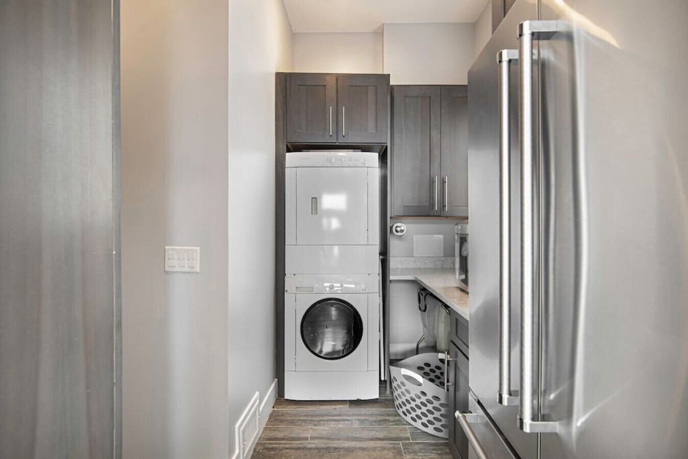 A compact kitchen with a built-in washer and dryer, a microwave, and a stainless steel refrigerator.
