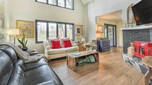 A spacious living room with a leather sofa, a coffee table, and a fireplace.