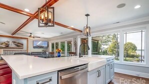 A modern kitchen with a large island, white cabinetry, and a dishwasher. - Lakefront home with private beach & gourmet kitchen (Sherrills Ford)