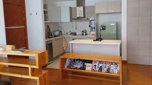 Una cocina moderna con armarios blancos, horno empotrado y refrigerador.