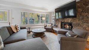 A modern living room with a stone fireplace, comfortable seating, and large windows. - Lodge Tower 487 3BR at the base of Vail Mountain (Vail)