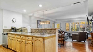 A spacious kitchen with wooden cabinets, a granite countertop, and a built-in island. - Lodge Tower 487 3BR at the base of Vail Mountain (Vail)