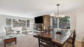 Un amplio comedor con una gran mesa de madera, sillas cómodas y una chimenea de piedra.