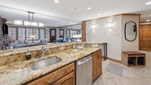 A modern kitchen with granite countertops, stainless steel sink, and wooden cabinets. - Lodge Tower 277 3BR at the base of Vail Mountain (Vail)