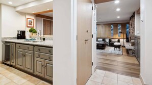 A modern kitchen with built-in cabinets, a countertop, and a dining area with a table and chairs. - Lodge Tower 287 3BR at the base of Vail Mountain (Vail)