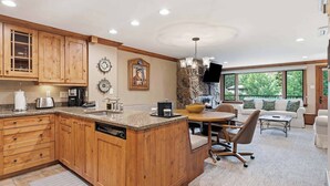 A kitchen with wooden cabinets, a granite countertop, and a stone backsplash. - Lodge Tower 294 2BR at the base of Vail Mountain (Vail)