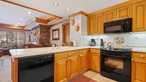 A modern kitchen with wooden cabinets, a built-in dishwasher, a microwave, and an oven.