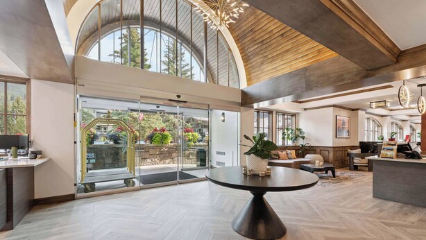 Un hall d’entrée spacieux, doté d’une grande table ronde, d’un comptoir d’accueil et offrant une vue sur l’extérieur grâce à une porte vitrée.