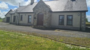 A stone building with a pitched roof and a central entrance.