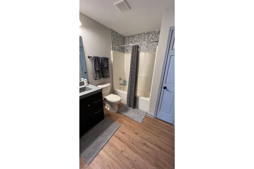 A bathroom with a toilet, sink, and shower area.