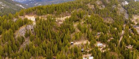 Un paisaje montañoso con casas dispersas rodeadas de bosques densos.
