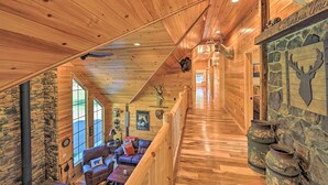 A wooden interior with a stone wall, a staircase, and a fireplace. - Unadilla Cabin on 50 Acres + Fire Pit & Creek (Unadilla)