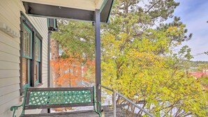 A green bench on a porch with a view of trees and a building. - Mountain-View Lead Home w/ Patio + Fire Pit! (Lead)