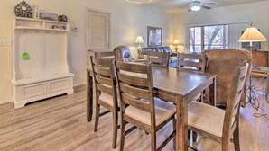 A dining area with a wooden table and chairs, a white bench, and a ceiling fan. - Cozy Condo w/ Nature Views: Branson Getaway (Branson West)