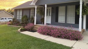 A residential house with a grey exterior, white trim, and a front porch. - Country Living in Oxford (Oxford)
