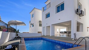 A swimming pool with a tiled deck, lounge chairs, and a covered seating area. - Sanders White Mountains - Vibrant Villa With Pool (Tremithousa)