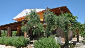 A two-story house with a covered patio area, surrounded by various types of vegetation. - Meridiana Holiday House With Shared Swimming Pool (Itri)