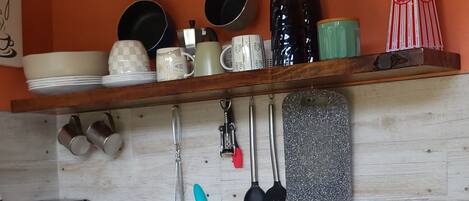 A kitchen with a wooden countertop, a sink, and various kitchen utensils and appliances.