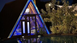 A modern, triangular-shaped building with a reflective pool in front. - A unique way to camp in luxury (Aguadilla Pueblo)