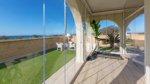 Ein Balkon mit Glaswand, Laufband und Meerblick.