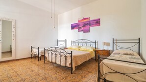 A bedroom with two beds, a large mirror with lights, a wall-mounted artwork, and patterned flooring. - 2929 Villa Garden Rose by Barbarhouse (Porto Cesareo)