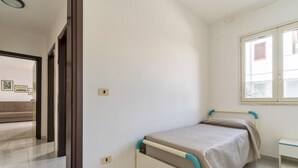 A bedroom with a bed, a window, and a door leading to another room. - 2811 Villetta Altomare by Barbarhouse (Porto Cesareo)
