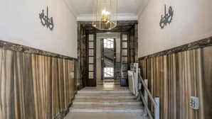 A grand staircase with marble steps leading to a door with glass panels. - Wonderful 1 Bedroom Apartament in the City Center (Rome)