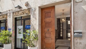 A hotel entrance with a wooden door, potted plants, and a sign indicating the address. - Wonderful 1 Bedroom Apartament in the City Center (Rome)