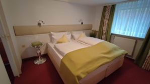 A hotel room with a bed, bedside lamps, a small table with a lamp, and a window with curtains. - Room in Guest Room - Pension Forelle - Doppelzimmer (Forbach)