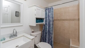 Een badkamer met een wastafel, toilet en douchegordijn.