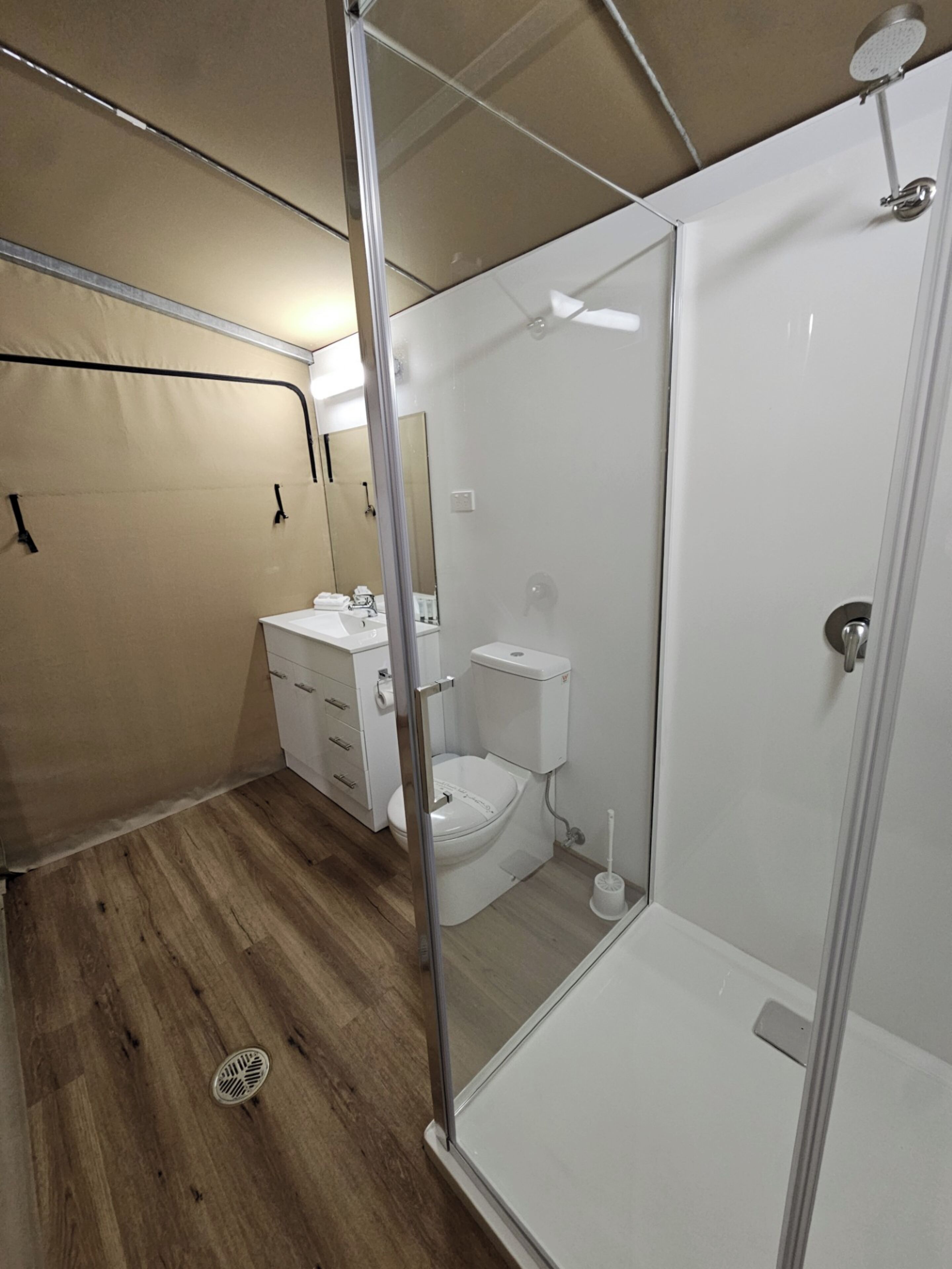Un baño pequeño con inodoro, lavamanos y ducha.