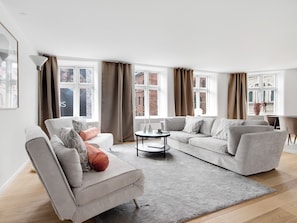 A modern living room with a sofa, armchair, and a coffee table.