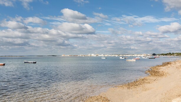 A coastal scene with calm waters, boats, and a sandy beach. - 1975 Villetta La Pineta 2 by Barbarhouse (Porto Cesareo)