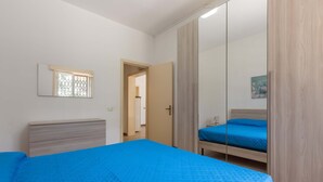 A bedroom with a large bed, a wardrobe, and a mirror. - 1975 Villetta La Pineta 2 by Barbarhouse (Porto Cesareo)