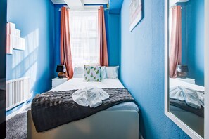 Relax in this inviting room with a neatly made bed, window with a view, and a mirror reflecting the interior.