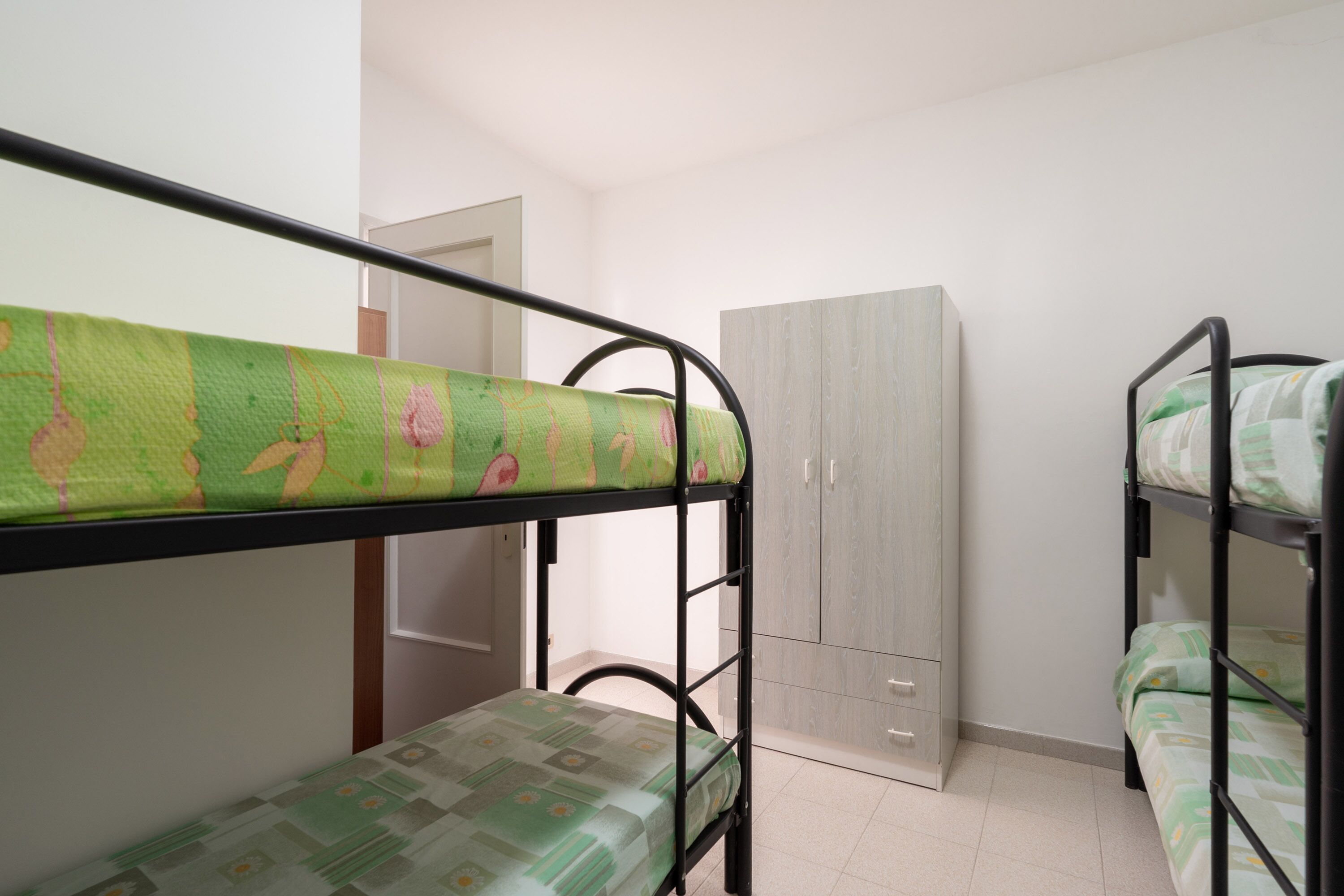 Habitación con literas, un armario y una puerta.