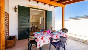 An outdoor dining area with a table set for two, a wooden pergola overhead, and a view of the adjacent building. - 2960 Villetta Stella Mary - Bilo 2 by Barbarhouse (Nardò)
