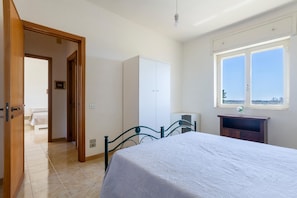 A bedroom with a bed, wardrobe, and a window. - 2922 Villetta Marelia by Barbarhouse (Porto Cesareo)