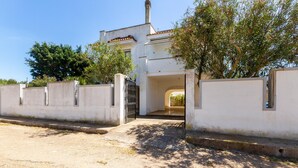 A white building with a gated entrance, a chimney, and a paved driveway. - 2922 Villetta Marelia by Barbarhouse (Porto Cesareo)