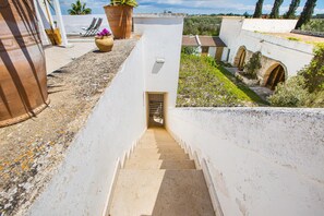 A narrow staircase leading to a door, surrounded by white walls and a garden. - 3003 Masseria Surani Grande- Appartamento Sinistra by Barbarhouse (Manduria)