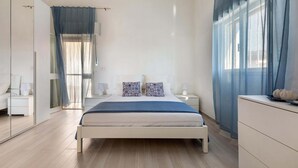 A modern bedroom with a large bed, bedside tables, a wardrobe, and a view through sheer curtains. - 2725 Villa Beatrice by Barbarhouse (Manduria)