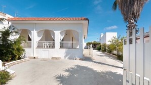 A white building with a red-tiled roof, a covered patio with white railings, and a palm tree in the foreground. - 2725 Villa Beatrice by Barbarhouse (Manduria)