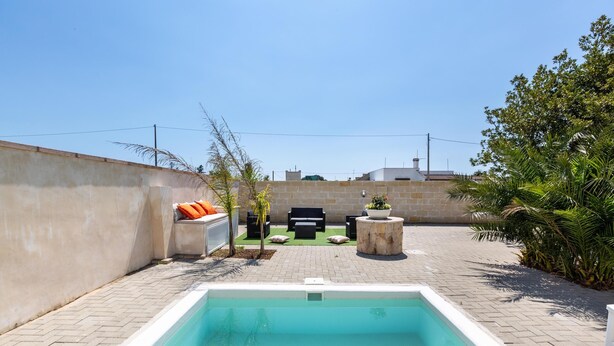 A swimming pool with a brick patio, outdoor furniture, and a stone wall. - 2671 Villetta Holly by Barbarhouse (Lizzano)