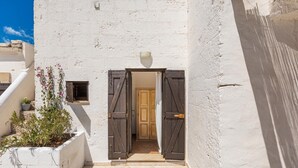 A white building with a doorway, a small potted plant, and a tiled floor. - 3002 Masseria Surani Grande- Appartamento Destra by Barbarhouse (Manduria)